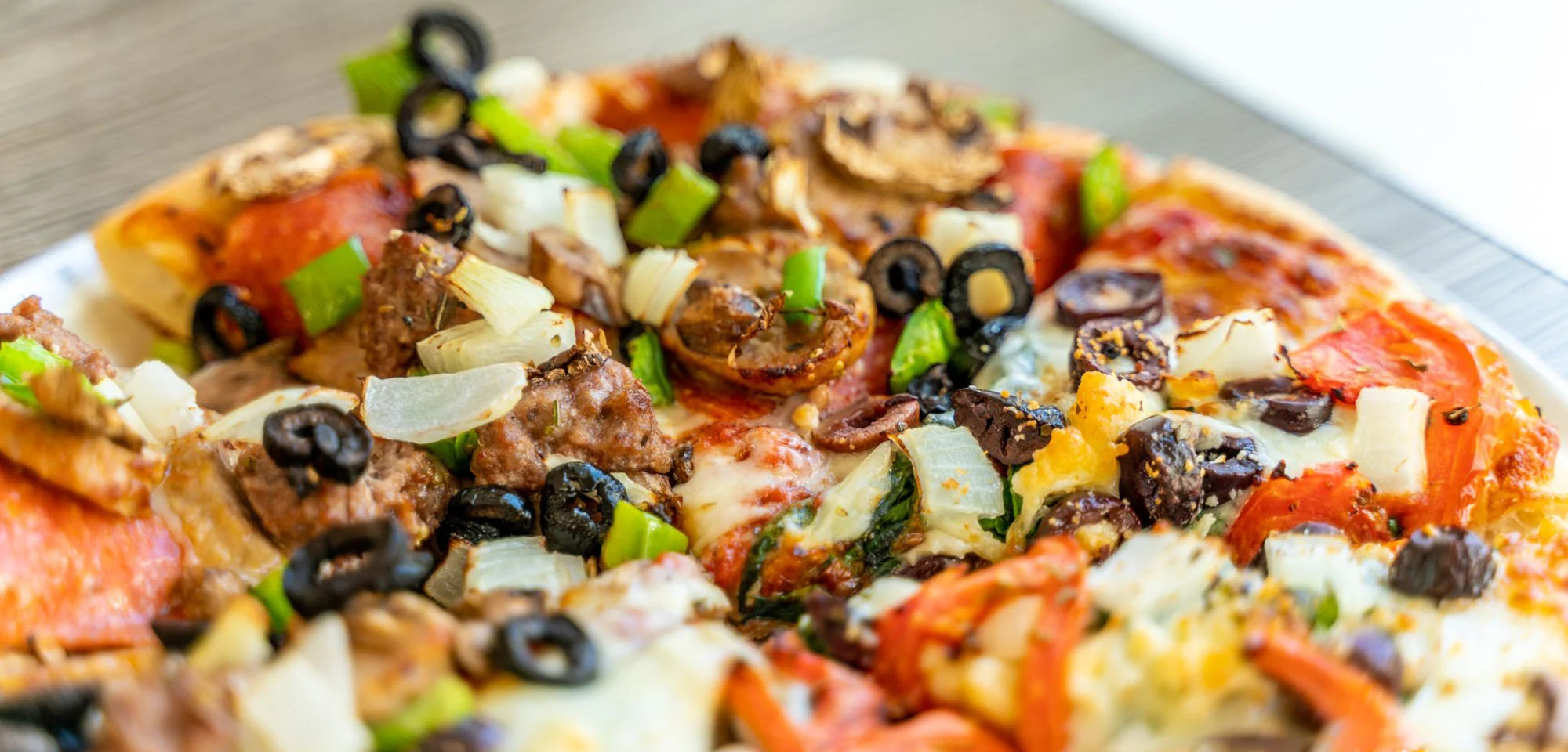 Fresh vegetable and sausage pizza featured on the Arundel House of Pizza website